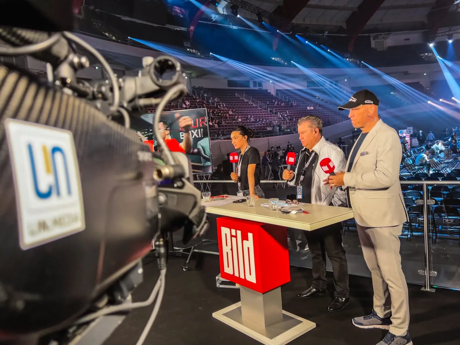 Studio-Präsentation vor den Rängen der Arena mit LIN.Media-Kamera und Moderationspult