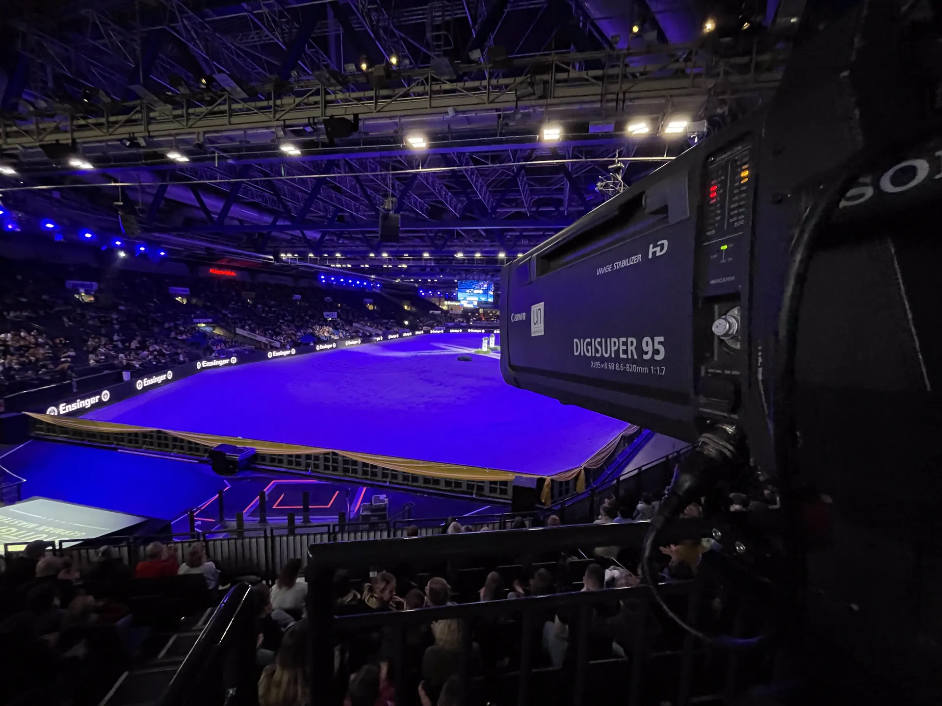 Kamera mit Canon Digisuper 95 vor voll besetzter Arena in blauem Licht