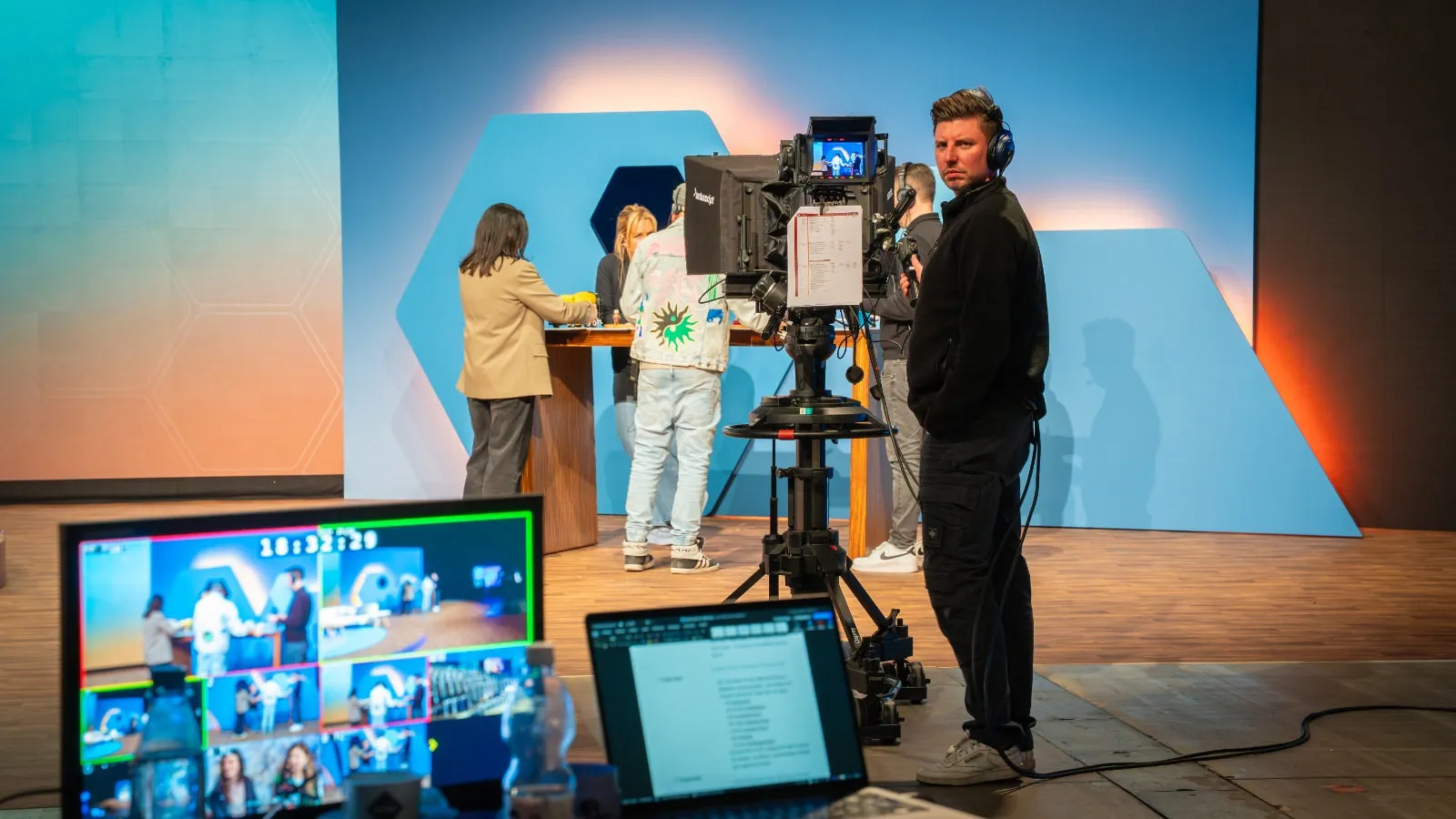 Kameramann mit Headset an der Studiokamera mit Teleprompter, im Vordergrund der Multiviewer mit Timecode