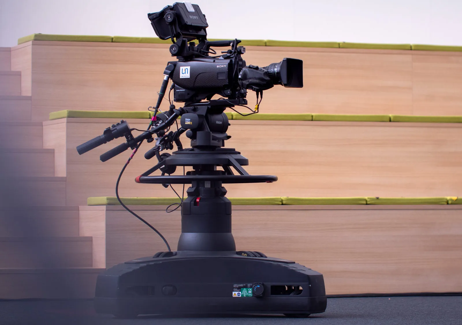 Sony-Studiokamera mit LIN.Media-Logo auf einem Pedestal vor einer Holztribüne